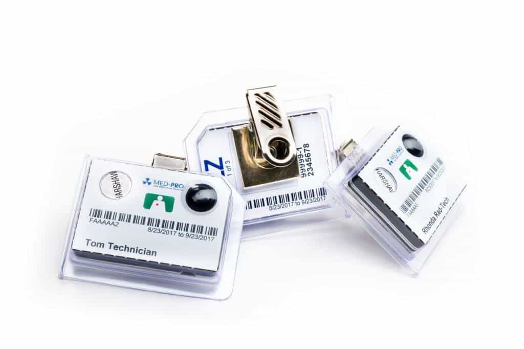 Three Med-Pro radiation detection dosimeter badges.